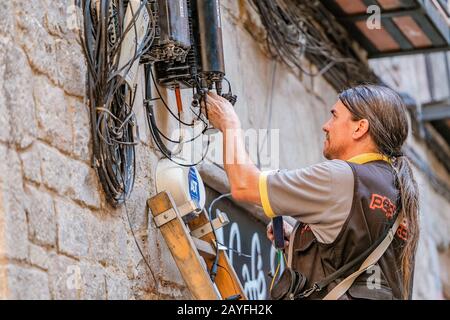 12 JULY 2018, BARCELONA, SPAIN: electrician engineer works with cables in electric network at city street Stock Photo