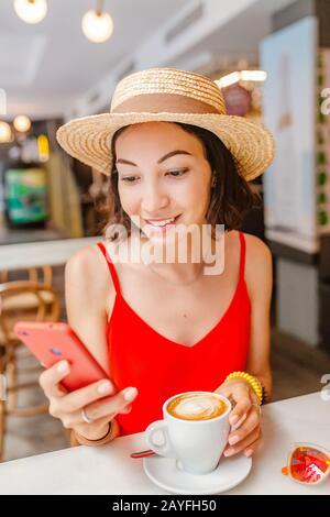 Happy asian woman using mobile phone during breakfast in coffee shop Stock Photo