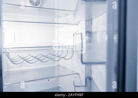 Empty open fridge with shelves in the kitchen at night Stock Photo