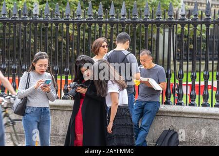 Cambridge, UK, August 1, 2019. Turists walking down and taking pictures at the street of Cambridge on a busy sunny day in front of Kings College Stock Photo