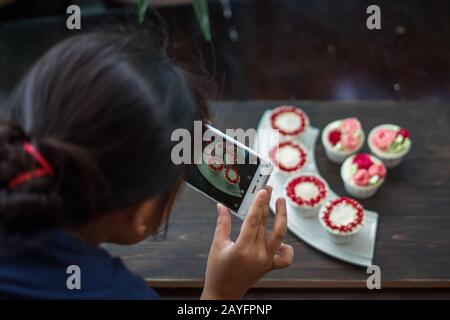 Beautiful cup cakes flowers from butter cream, in red and pink colour. Suitable for Birthday, Anniversary, Valentine Day and festive. selective focus Stock Photo