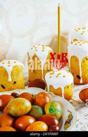 Easter eggs in a plate, Easter cake on an old white wooden background, retro style, rustic Stock Photo