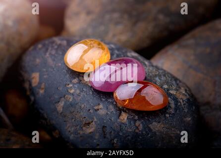 Round cut mineral gemstones with dark stones background. Stock Photo