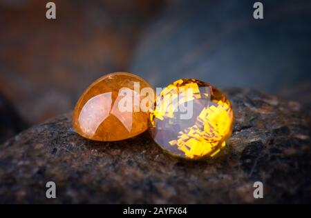Round cut yellow mineral gemstones with stone background. Stock Photo