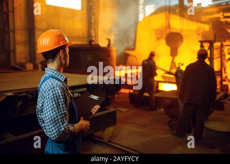 Master looks on steelmaking process in furnace Stock Photo