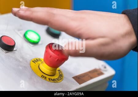 Hand pressing the red emergency button or stop button for industrial machine, Emergency Stop for Safety . Stock Photo