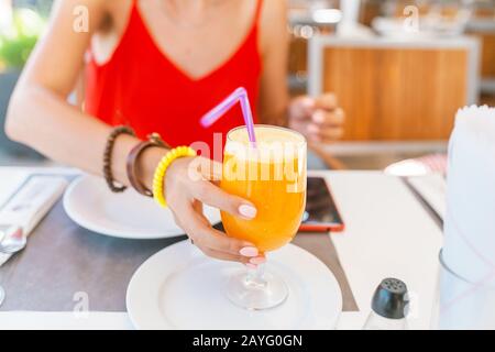 young woman drinking orange juice at restaurant bar Stock Photo