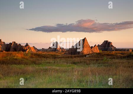 SD00100-00...SOUTH DAKOTA - Rock towers and spires at sunrise in the open prairie at Badlands National Park. Stock Photo