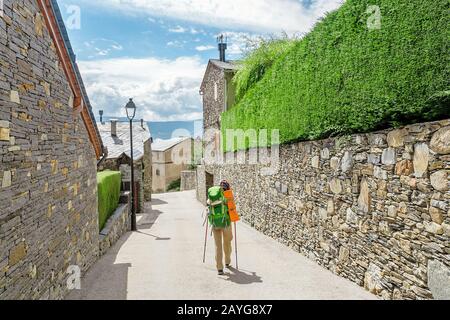 Pilgrim Woman hiker on a route trail across the old town or village Stock Photo