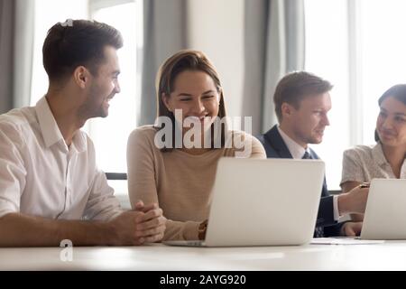Diverse employees work in groups discussing ideas in office Stock Photo