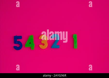 Numbers placed in a row against colorful background Stock Photo