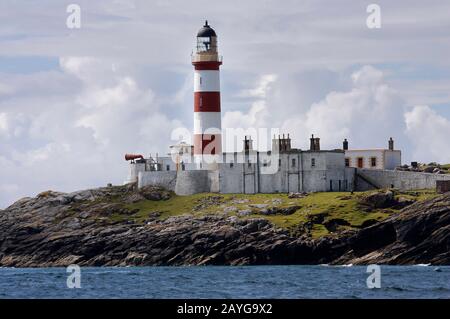 The tall, red and white striped Eilean Glas lighthouse, Scalpay, from the sea, Western Isles, Scotland Stock Photo