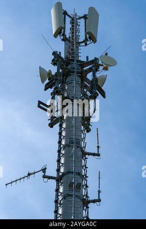 Closeup of mobile telecommunication tower or cell tower with antennae and electronic communications equipment - Vertical format Stock Photo
