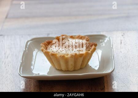 A close up view of a small home made milk tart on a white side plate Stock Photo