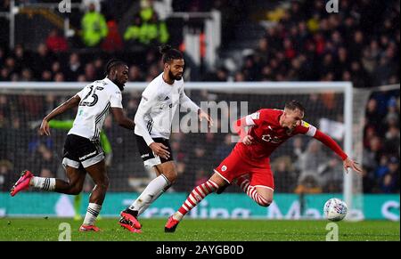 Barnsley's Cauley Woodrow (right) falls down during the Sky Bet Championship match at Craven Cottage, London. Stock Photo