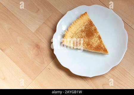 A close up view of a slice of homemade milk tart on a side plate Stock Photo