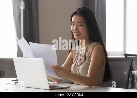 Young Asian female working with paper documents in office Stock Photo