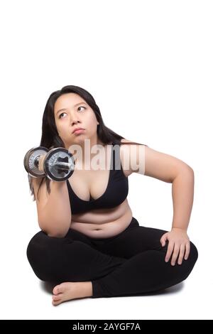 beautiful chubby fat woman lift dumbbell sitting on ground doubt about exercise weight training Stock Photo