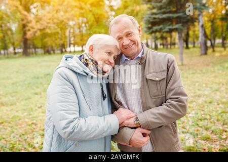 Senior Couple Walking in Autumn Park Stock Photo