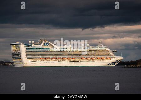 Large cruise ship Caribbean Princess departing Halifax Harbour against a grim sky. Stock Photo