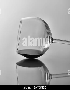 Wine Glass Still Life: Black and white image of a wine glass on its side with reflection. Stock Photo