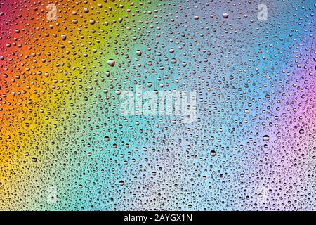 Water Drops on multi-colored rainbow Background. Stock Photo