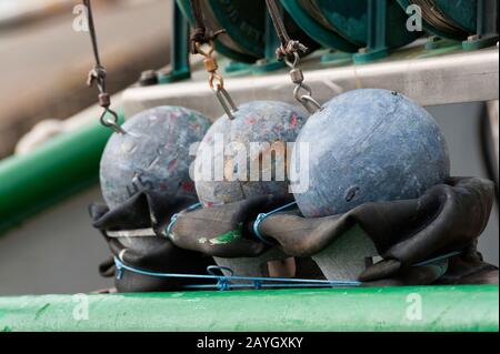 Close up of fishermen's round iron balls used for anchoring nets part of the fisherman's equipment on boat in the marina in Newport, Oregon. Stock Photo