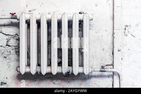 Old cast-iron heating radiator in grunge style. Stock Photo