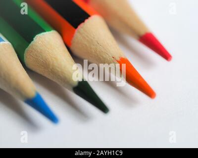 Soft focus close up of coloured pencil nibs on white paper Stock Photo