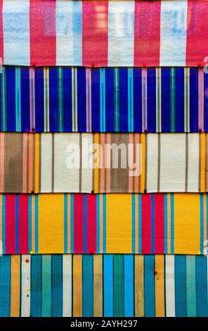 Bold colours in cultural and etchnic patterns on fabric pinned to board. Vibrant and colourful stripes horizontally. Stock Photo