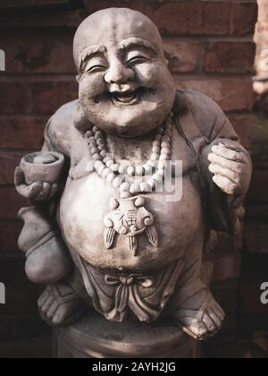 Close up of laughing Buddha garden statue Stock Photo