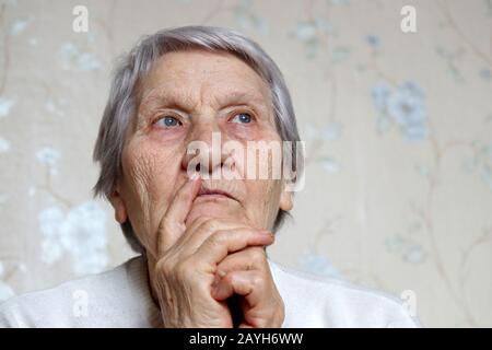 Portrait of elderly woman with a peaceful face thinking about something. Concept of brain activity in old age, memories of the past Stock Photo