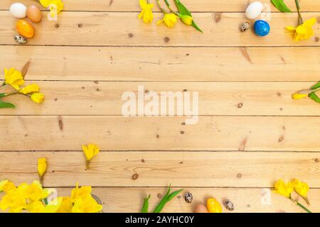 spring background decoration with Easter bells, daffodils flowers and easter eggs on wooden floor in old building. spring decoration or easter decorat Stock Photo