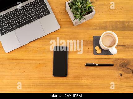 Table Top desk view with pencil a plant, coffee, workspace, business, smartphone laptop Stock Photo