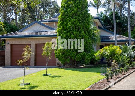 Australian home and garden with double garage  plants and grass in the Sydney suburb of Mona Vale,New South Wales,Australia Stock Photo