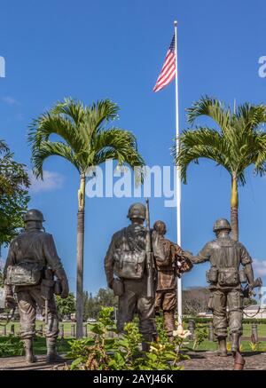 Oahu, Hawaii, USA. - January 10, 2012: United In Sacrifice group statue seen from back in front of US flag under blue skay at Schofield Barracks of Ar Stock Photo