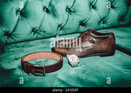 Brown man shoes with belt and watch on green sofa Stock Photo