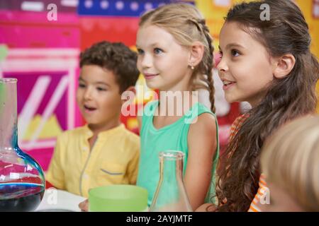 Happy children doing chemical experiments in playroom. Stock Photo