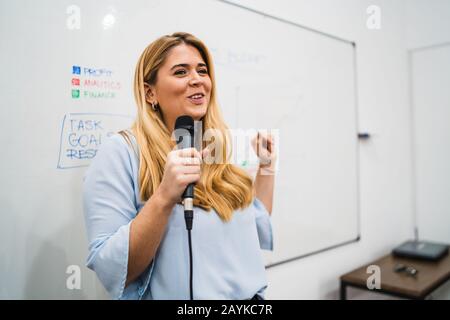 Friendly business woman explaining plan of work and answering questions on a work conference. Business concept. Stock Photo