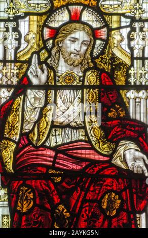 Victorian stained glass window showing Jesus Christ in red robes pointing to heaven.  On public display over 100 years. Stock Photo