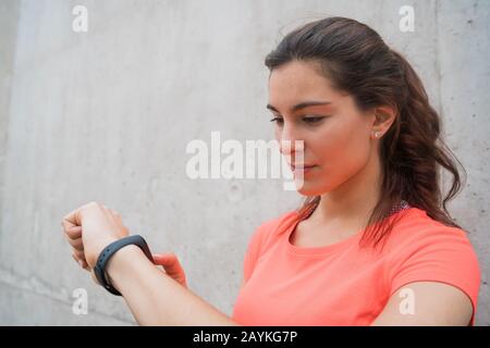 Portrait of a fitness woman checking time on her smart watch. Sport and healthy lifestyle concept. Stock Photo