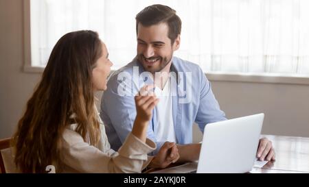 Happy millennial couple have fun using laptop Stock Photo