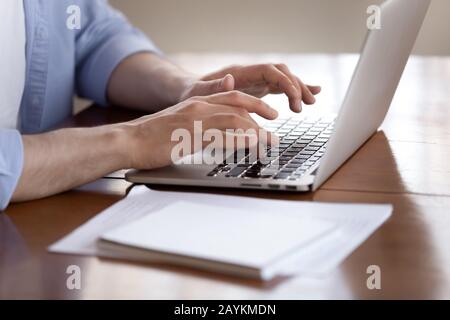 Male worker busy typing on modern laptop Stock Photo