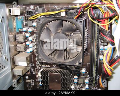 Dust on the computer pc processor cooler with mainboard and computer case fragment. Selective focus. Stock Photo