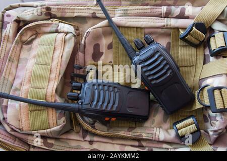 Pair of portable radio sets on the background of a military backpack camouflage modern army radio Stock Photo