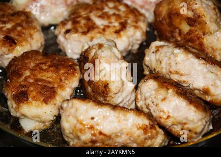 Juicy homemade meat cutlets with crispy crust are fried in a frying pan. Close up background. Stock Photo