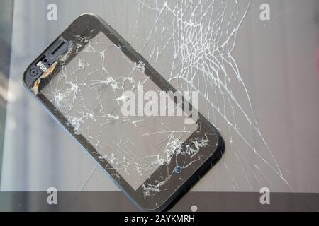 A smartphone with a broken screen and a tablet computer with a broken touchscreen. Broken glass texture. Stock Photo