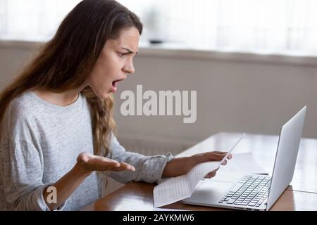 Shocked young woman read band news in letter at home Stock Photo