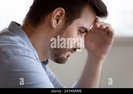 Unhappy young man lost in thought having troubles Stock Photo