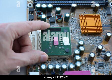 Hand of computer engineering plugging computer cpu processor memory change components into socket processor. Computer technology and hardware maintena Stock Photo